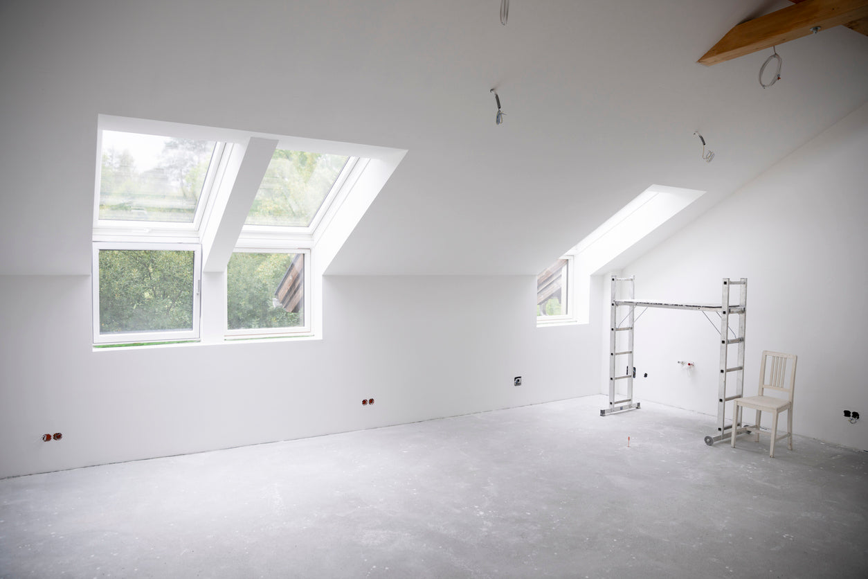 Combles en cours de rénovation avec murs et plafonds fraîchement peints, fenêtres de toit apportant une belle luminosité naturelle et finitions en cours, réalisés par La Haute Peinture à Sallanches.