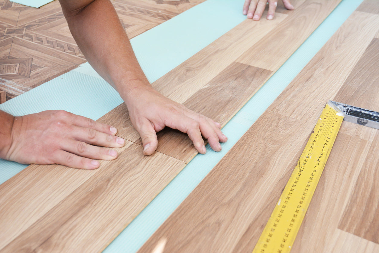Pose de parquet flottant effet bois dans une maison à Sallanches en Haute-Savoie. Artisan spécialisé en rénovation intérieure, pose de revêtement de sol, parquet stratifié, préparation du support, finitions soignées, rénovation de maison et appartement par La Haute Peinture.
