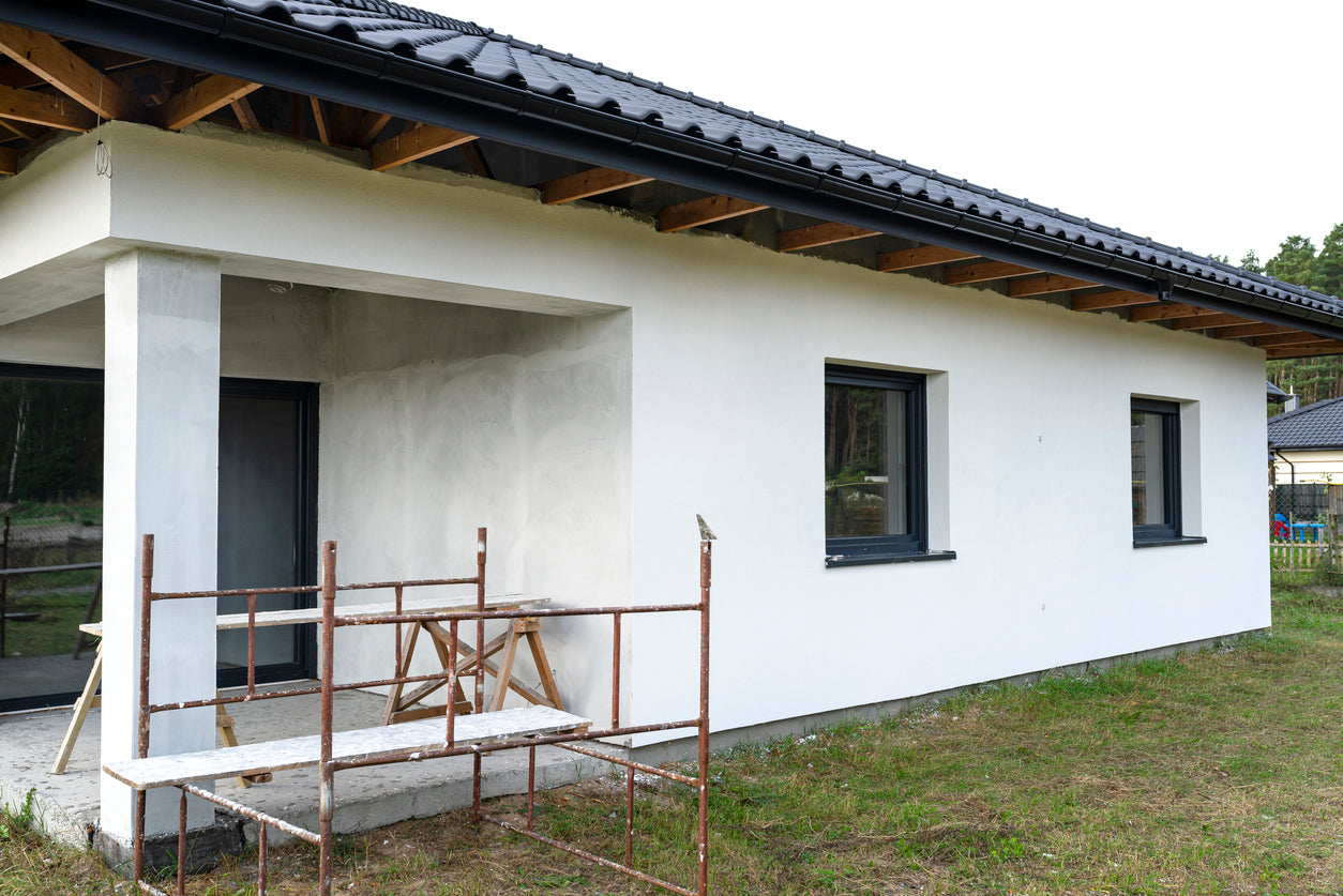 Ravalement de façade et peinture extérieure sur une maison neuve à Collonges-sous-Salève en Haute-Savoie par La Haute Peinture. Application d'un enduit de finition, peinture de façade blanche, protection durable contre les intempéries et finitions soignées pour une maison moderne.