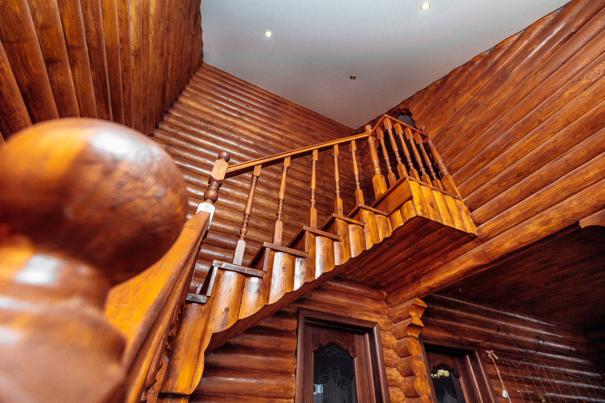 Rénovation d'un chalet en bois avec application d'une lasure de protection sur les murs et l'escalier à Rumilly en Haute-Savoie par La Haute Peinture. Traitement du bois intérieur, mise en valeur du veinage naturel et protection durable pour une finition chaleureuse et authentique.
